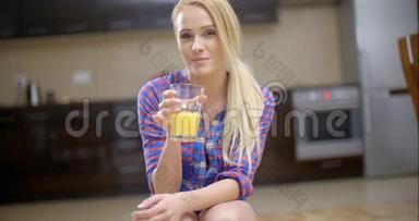 漂亮的金发女人在杯子里<strong>喝果汁</strong>